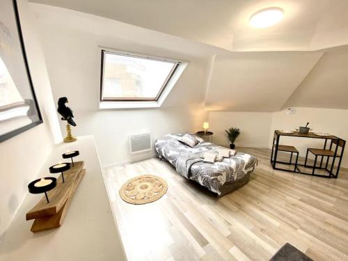 een slaapkamer met een bed, een tafel en een raam bij LeNew 3 - Centre-ville - TV - WIFI in Calais