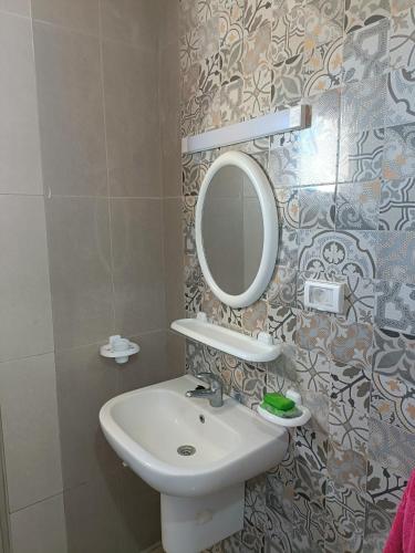 a bathroom with a sink and a mirror at Family Yahia in Ḩammām al Ghazzāz
