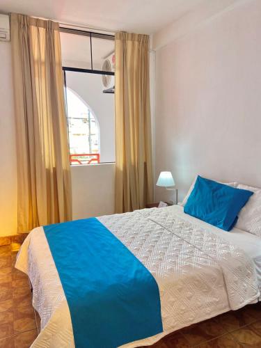 Schlafzimmer mit einem großen Bett und einem Fenster in der Unterkunft Hotel Firenze in Tarapoto