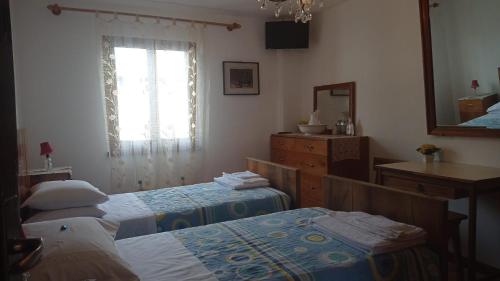 sypialnia z 2 łóżkami, umywalką i lustrem w obiekcie Antica Corte da Edi w mieście San Daniele del Friuli