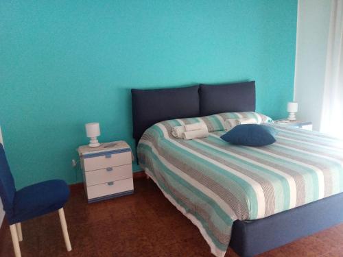 ein Schlafzimmer mit einem Bett und einer blauen Wand in der Unterkunft Casa Rosamarina in Mondello
