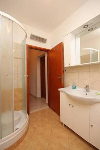 a bathroom with a sink and a shower and a mirror at Apartments Pašman in Banj