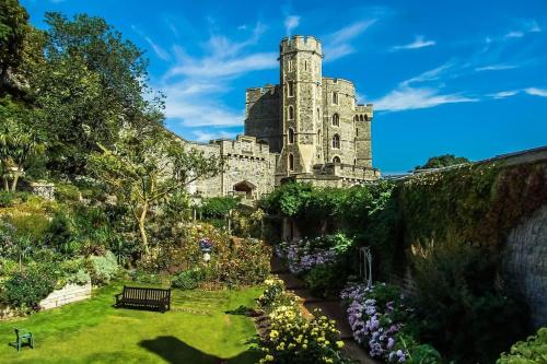 a garden with a castle in the background at BEAUTIFUL WINDSOR 2 BED, PERFECT LOCATION, 5 Mins Walk to Centre, Private Gated Parking, Legoland, Ascot in Windsor