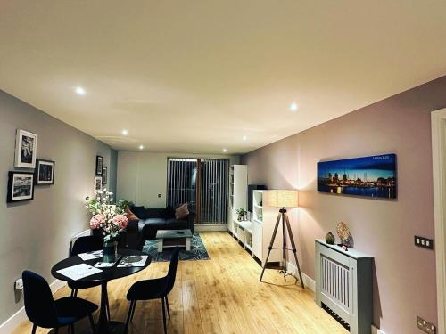 a living room with a couch and a table at Spacious Luxury Waterfront Apartment in Ipswich