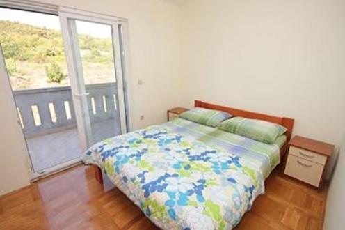 a bedroom with a bed and a large window at Apartments Pašman in Banj