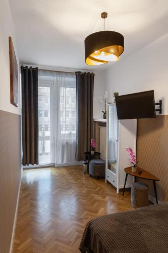 sala de estar con suelo de madera y cama en ClickTheFlat Krucza City Center Apart Rooms, en Varsovia