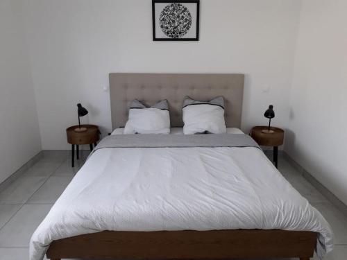 une chambre avec un grand lit blanc avec deux tables dans l'établissement Maison neuve de standing 150 m2, à Croix-Chapeau