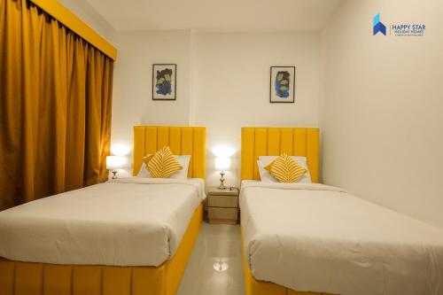 two beds in a room with yellow curtains at 2 BR Perfect for Family/Groups near MOE in Dubai