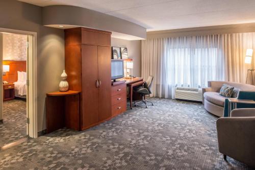 a hotel room with a television and a living room at Courtyard Clemson in Clemson