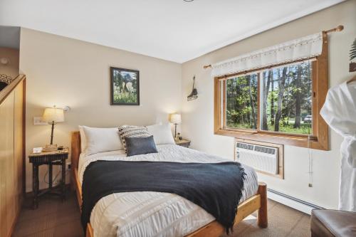 a bedroom with a bed and a window at Good Medicine Lodge in Whitefish