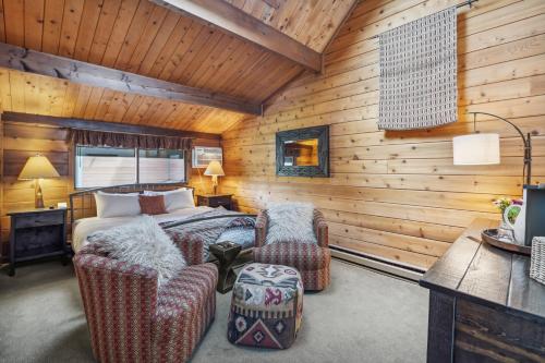 a bedroom with a bed and two chairs at Good Medicine Lodge in Whitefish