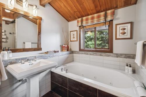 a bathroom with a tub and a sink at Good Medicine Lodge in Whitefish