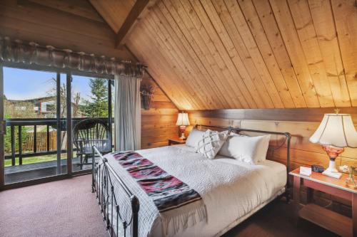 ein Schlafzimmer mit einem Bett und einem großen Fenster in der Unterkunft Good Medicine Lodge in Whitefish