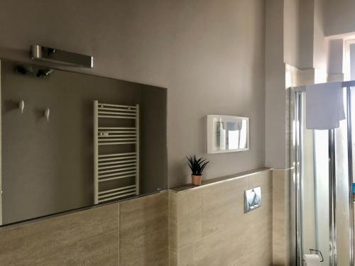 a bathroom with a large mirror on the wall at Attico Ellen terrazza con vista in Turin