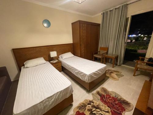 um quarto de hotel com duas camas e uma janela em Unique studio- Aqua View Resort em El Alamein