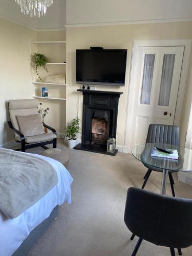 a living room with a fireplace and a tv at Tranquil Haven Murrayfield in Edinburgh