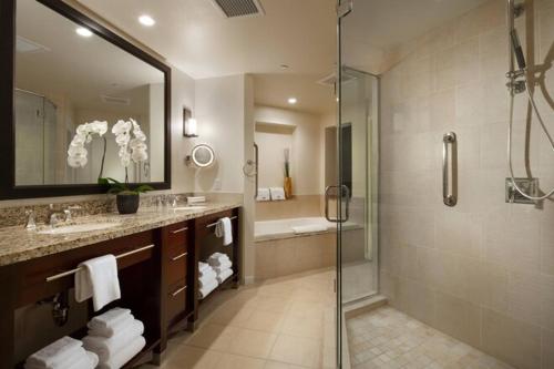 uma casa de banho com um chuveiro, um lavatório e uma cabina de duche em vidro. em Westin Mission Hills Villas Resort-XMAS em Rancho Mirage