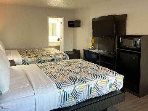 a hotel room with two beds and a flat screen tv at Motel 6-Lafayette, IN in Lafayette