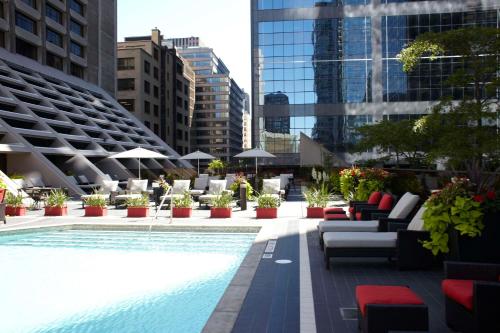 einen Pool mit Stühlen, Tischen und Gebäuden in der Unterkunft Hilton Toronto in Toronto