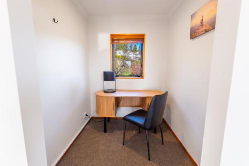 a room with a desk and a chair and a window at Wanaka Springs Lodge in Wanaka