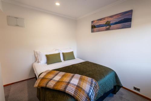 a bedroom with a bed and a painting on the wall at Wanaka Springs Lodge in Wanaka