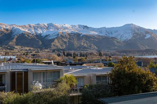 a view of snow covered mountains from a city at Wanaka Springs Lodge in Wanaka