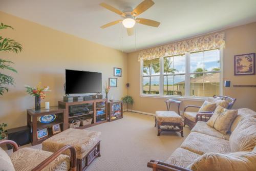a living room with couches and a flat screen tv at Princeville Condo with AC, Pool, Garage, Beach Gear 27B in Princeville