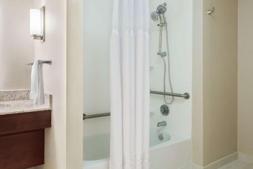 a bathroom with a shower with a white shower curtain at Homewood Suites by Hilton Baton Rouge in Baton Rouge