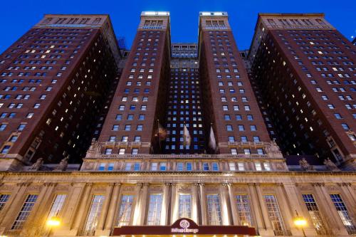 una vista de tres edificios altos por la noche en Hilton Chicago en Chicago