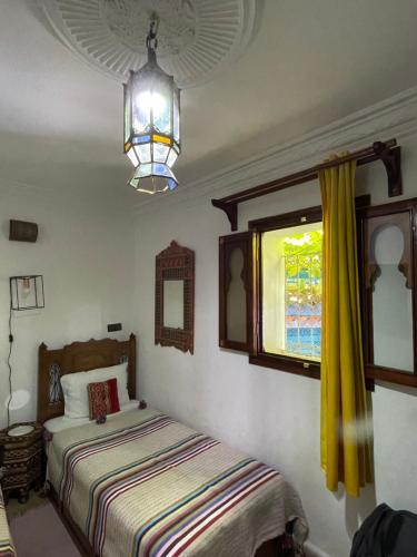 - une chambre avec 2 lits et une fenêtre dans l'établissement Dar Sababa, à Chefchaouen
