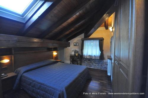 a bedroom with a blue bed and a window at Hotel Le Soleil in Challand Saint Anselme