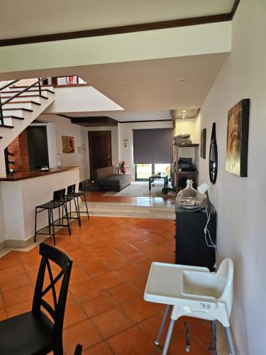 uma sala de estar com cadeiras, uma mesa e escadas em À Beira Lago - Casa de férias em Mira