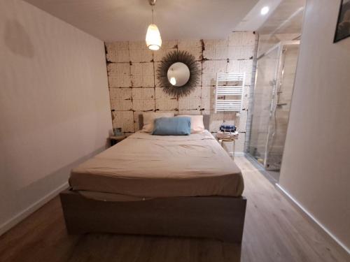 een slaapkamer met een bed en een spiegel aan de muur bij Maisonnette in Corbeil-Essonnes