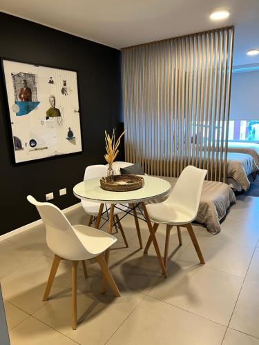 a dining room with a table and white chairs at Seaport Apartments STUDIO Austral 402 in Ushuaia