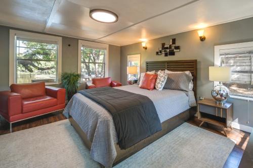 a bedroom with a large bed and a red chair at Waterfront Lake LBJ Cabin with Private Dock! in Burnet