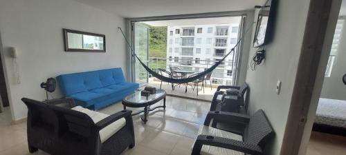 sala de estar con sofá azul y hamaca en Aqualina Orange Apartamento Piso 6 Vista a Piscina 3 Habitaciones, en Girardot