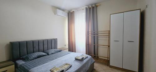 Un dormitorio con una cama con dos zapatos. en New Bazaar Side Bliss 2 Bed Room apt with free garage en Tirana
