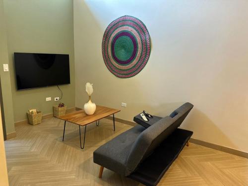 uma sala de estar com um sofá e uma mesa em Habitación 23 - Green Casitas em Ensenada
