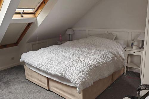 1 dormitorio con cama blanca y ventana en Property near Marina & Leisure en Portsmouth