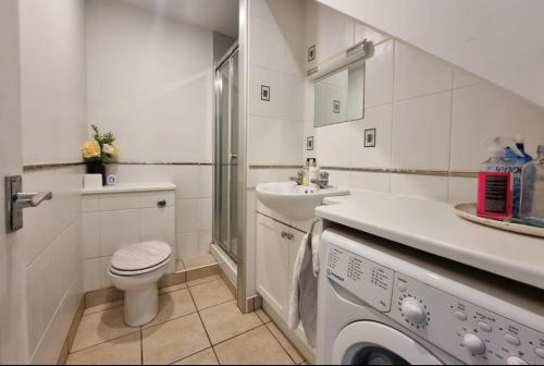 een witte badkamer met een toilet en een wastafel bij Property near Marina & Leisure in Portsmouth