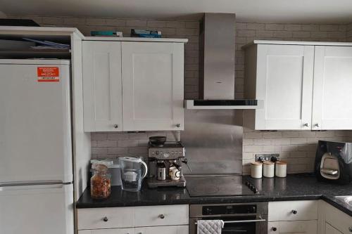 een keuken met witte kasten en een aanrecht bij Property near Marina & Leisure in Portsmouth