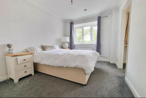 a white bedroom with a bed and a window at Property near Marina & Leisure in Portsmouth