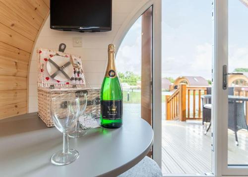 a bottle of champagne and two wine glasses on a counter at High Farm Holiday Park in Beverley