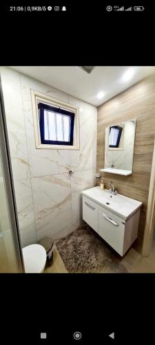 a bathroom with a sink and a toilet and a mirror at Vicky apartment in Paralimni