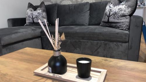 a black vase on a coffee table in front of a couch at The elegant Garden Room in Blackpool