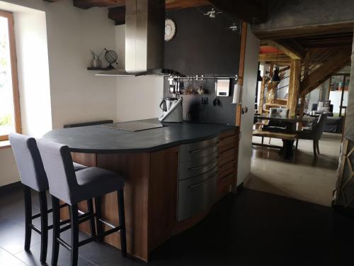 uma cozinha com uma ilha com um balcão e cadeiras em ChezSonBernois :) em Venizy