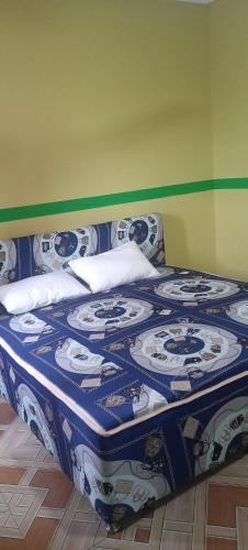 a bed with a blue and white blanket on it at Executive Lodge in Kasoa