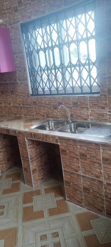 a bathroom with a sink and a window at Executive Lodge in Kasoa