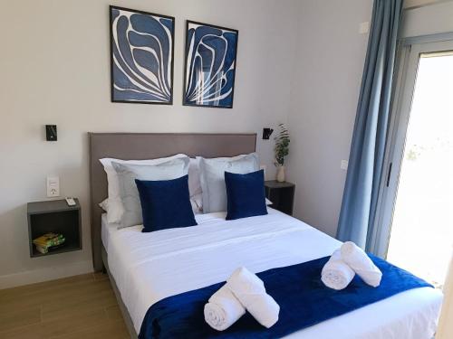 ein Schlafzimmer mit einem großen Bett mit blauen und weißen Kissen in der Unterkunft RAMBLA DREAMS Nuevo apartamento céntrico y 1GB in Santa Cruz de Tenerife