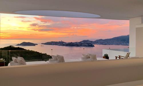 a dining room with a view of the ocean at Encanto Acapulco in Acapulco